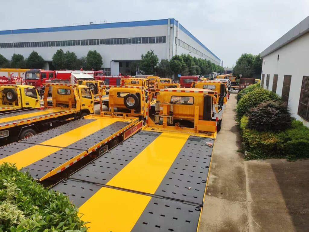 Multiple Rollback Tow Trucks Parked in Factory Yard Rear Left 45-Degree View
