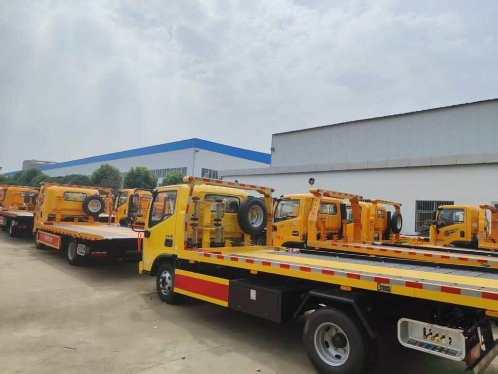 Multiple Rollback Tow Trucks Parked in Factory Yard Rear Right 45-Degree View