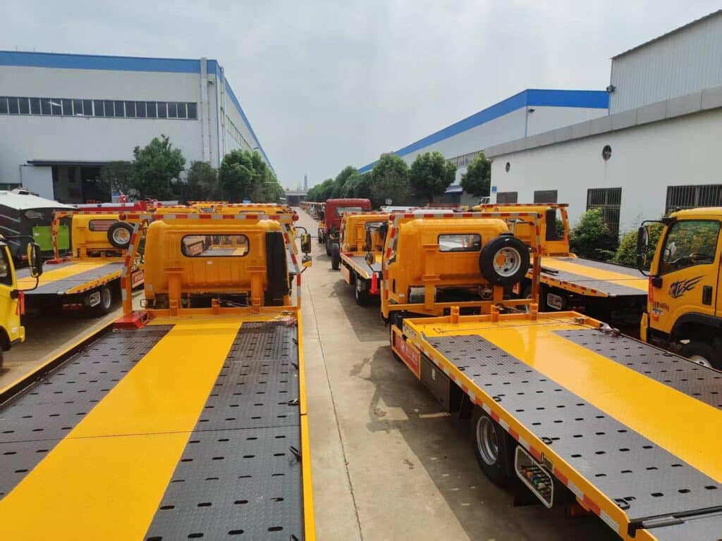 Multiple Rollback Tow Trucks Parked in Factory Yard Rear View