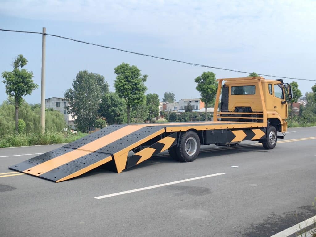 Right Side View of SINOTRUK Flatbed Tow Truck with Flatbed in Grounded Position