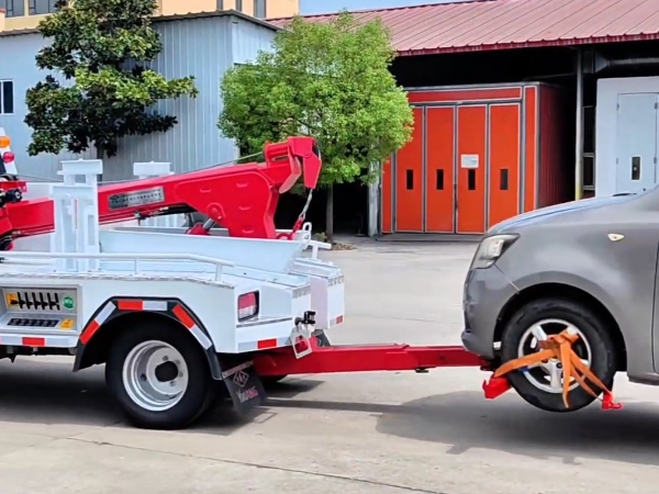 Close-up of the rear metal boom and Y-hook lifting a car’s front wheels