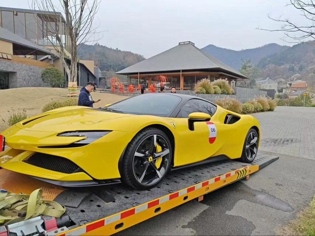 Low chassis sports car scraping front bumper on a standard tow truck ramp