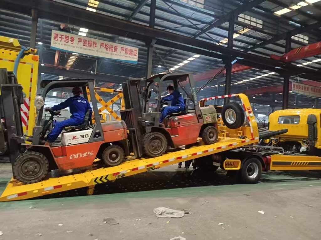3-ton flatbed tow truck loading a sedan with hydraulic deck inclined